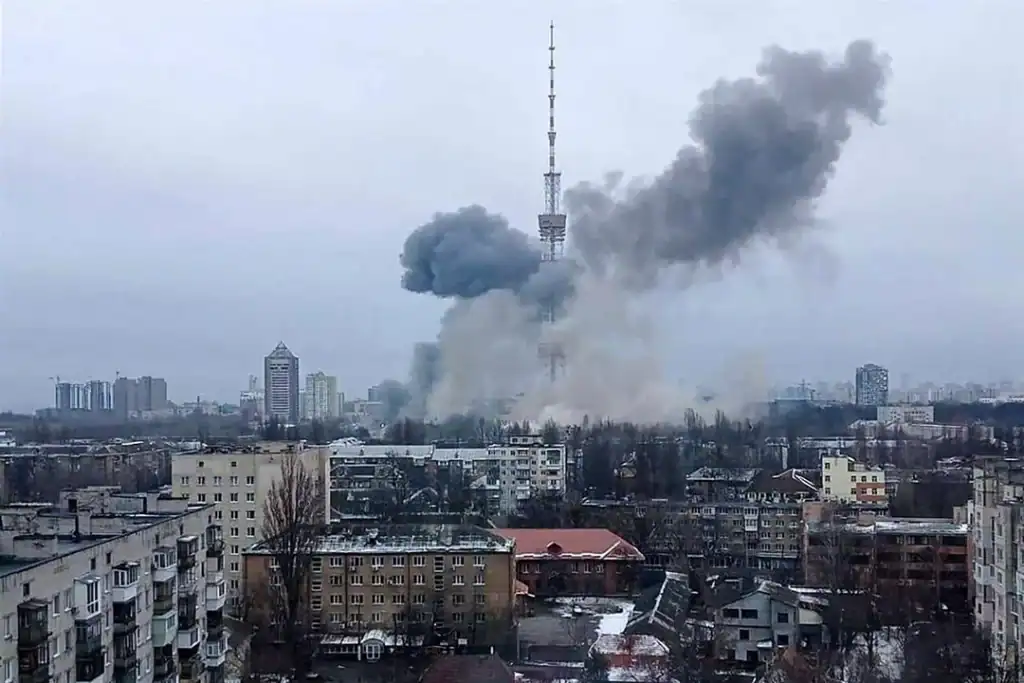 A large smoke plume rising from an explosion near the Kyiv TV tower during the war, seen over residential apartment blocks.