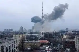 A large smoke plume rising from an explosion near the Kyiv TV tower during the war, seen over residential apartment blocks.