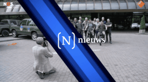 Still from the NOS Journaal news broadcast showing Protect Ukraine volunteers being photographed, featuring the NOS News banner.